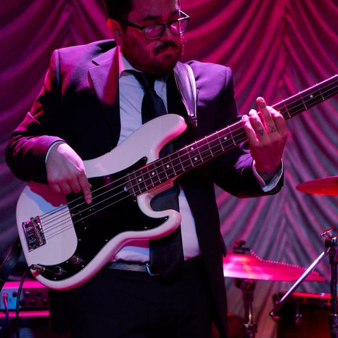 Bass player in a suit and tie with a white bass