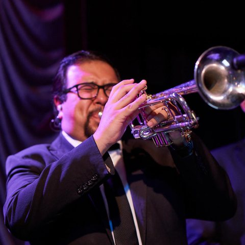 Trumpet player in a suit, mid-note